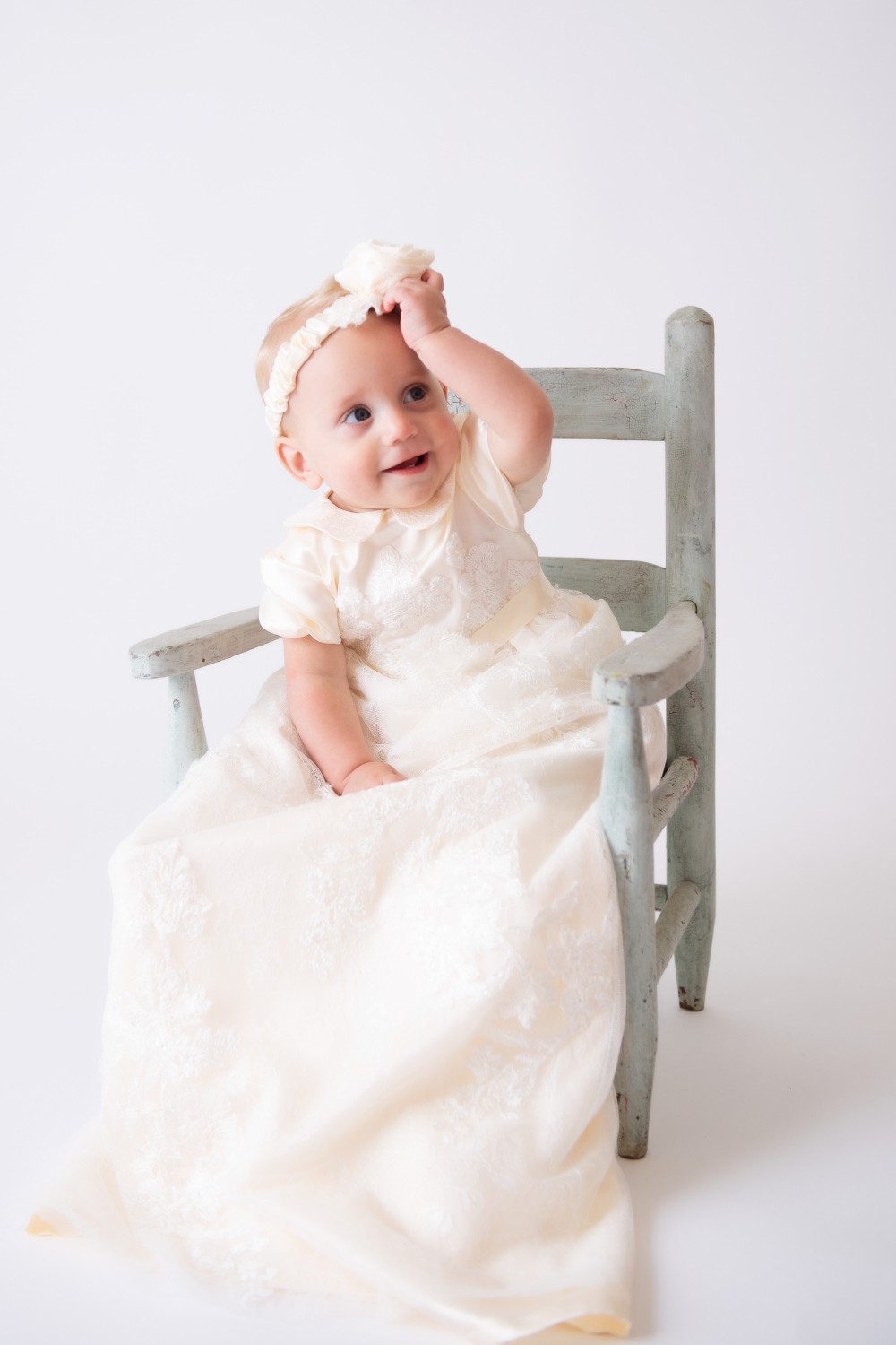 Baby wearing a white gown and flower headband