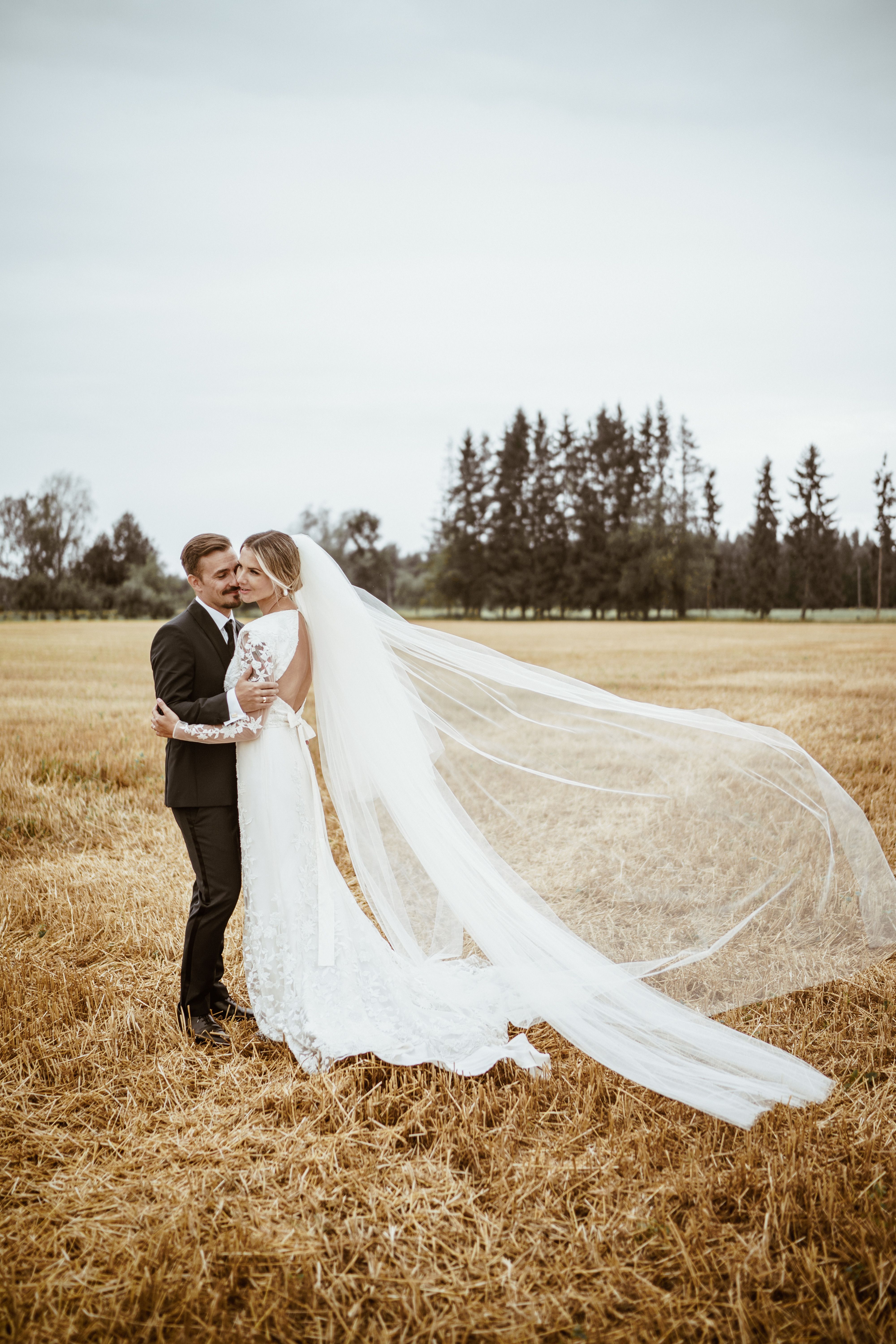 bride and groom standing in a field 