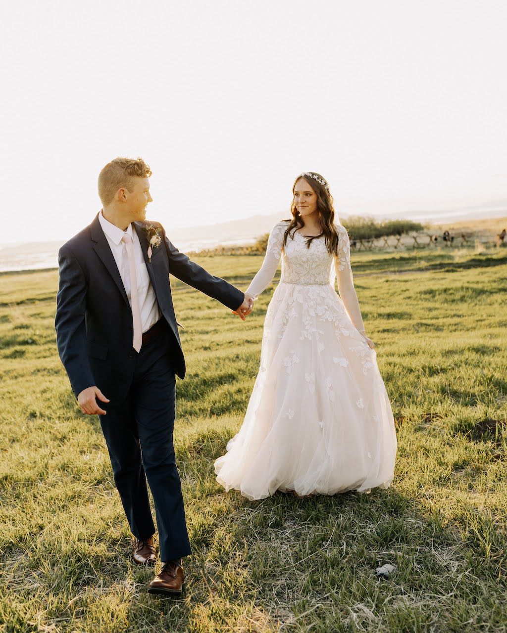 bride and groom in field at golden hour