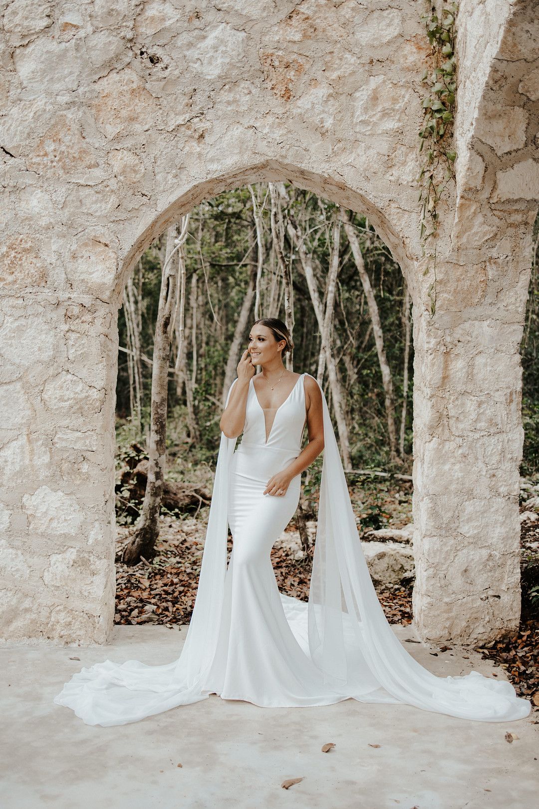 bride standing in front of arch way