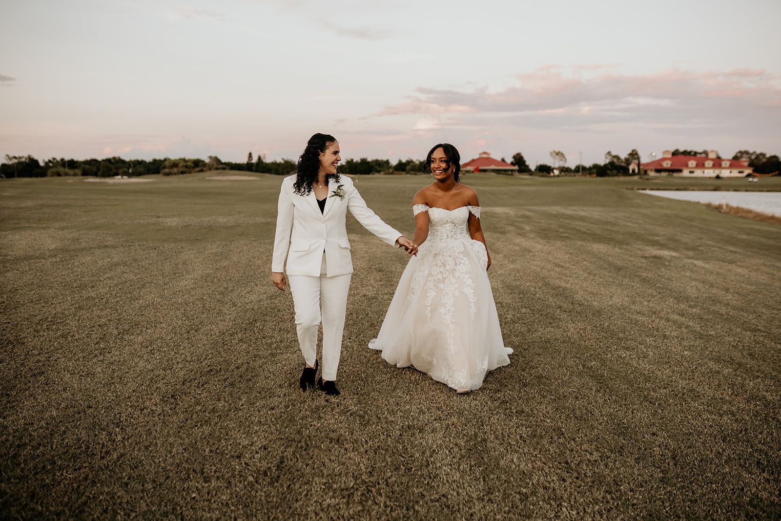 brides walking in field at intimate fall wedding