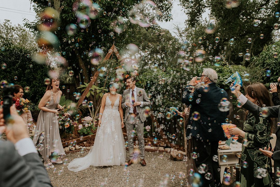 Celebratory moment filled with bubbles after bride and groom married at a coastal wedding in Big Sur, California