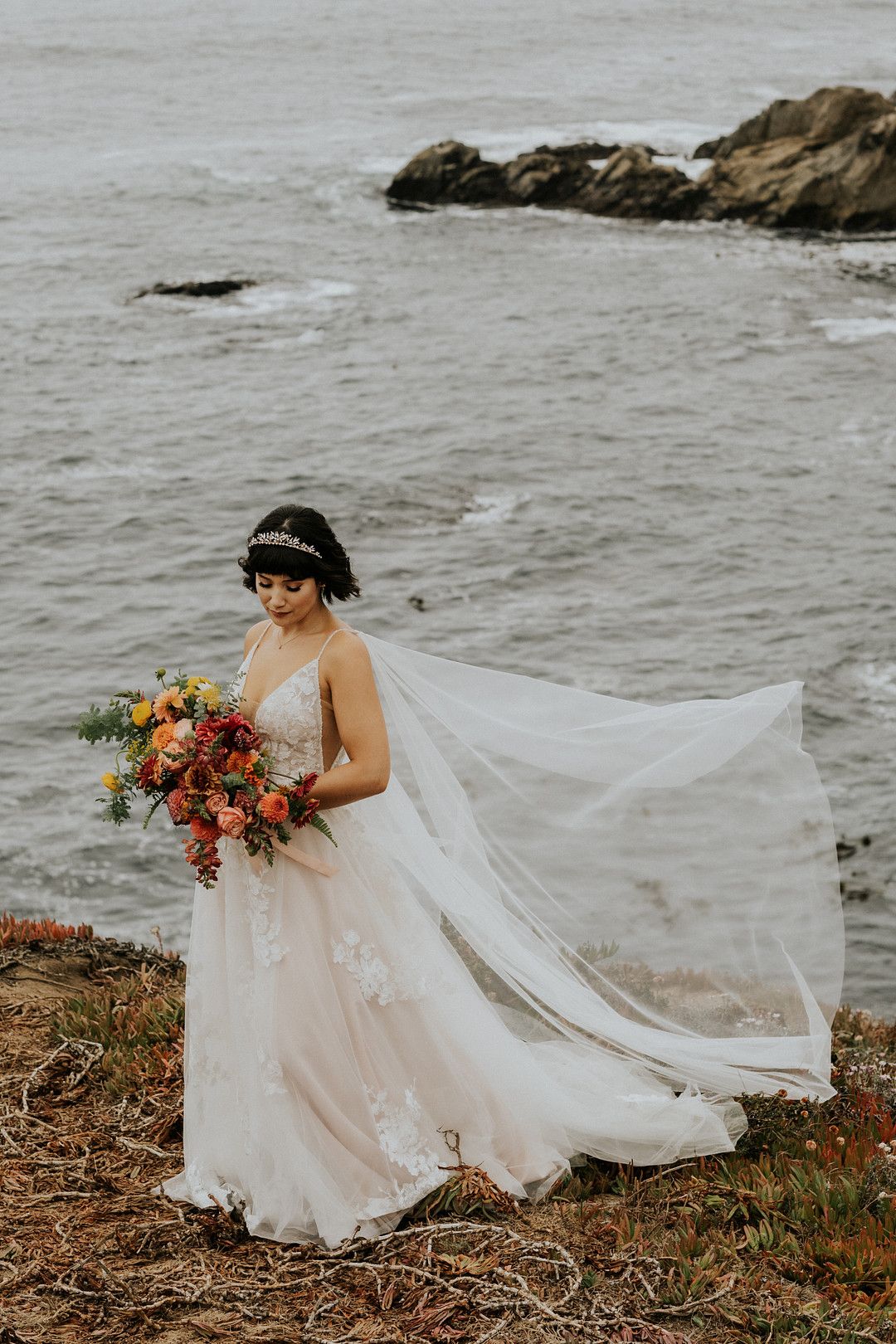 bride standing on cliff in a coastal wedding in Big Sur, California
