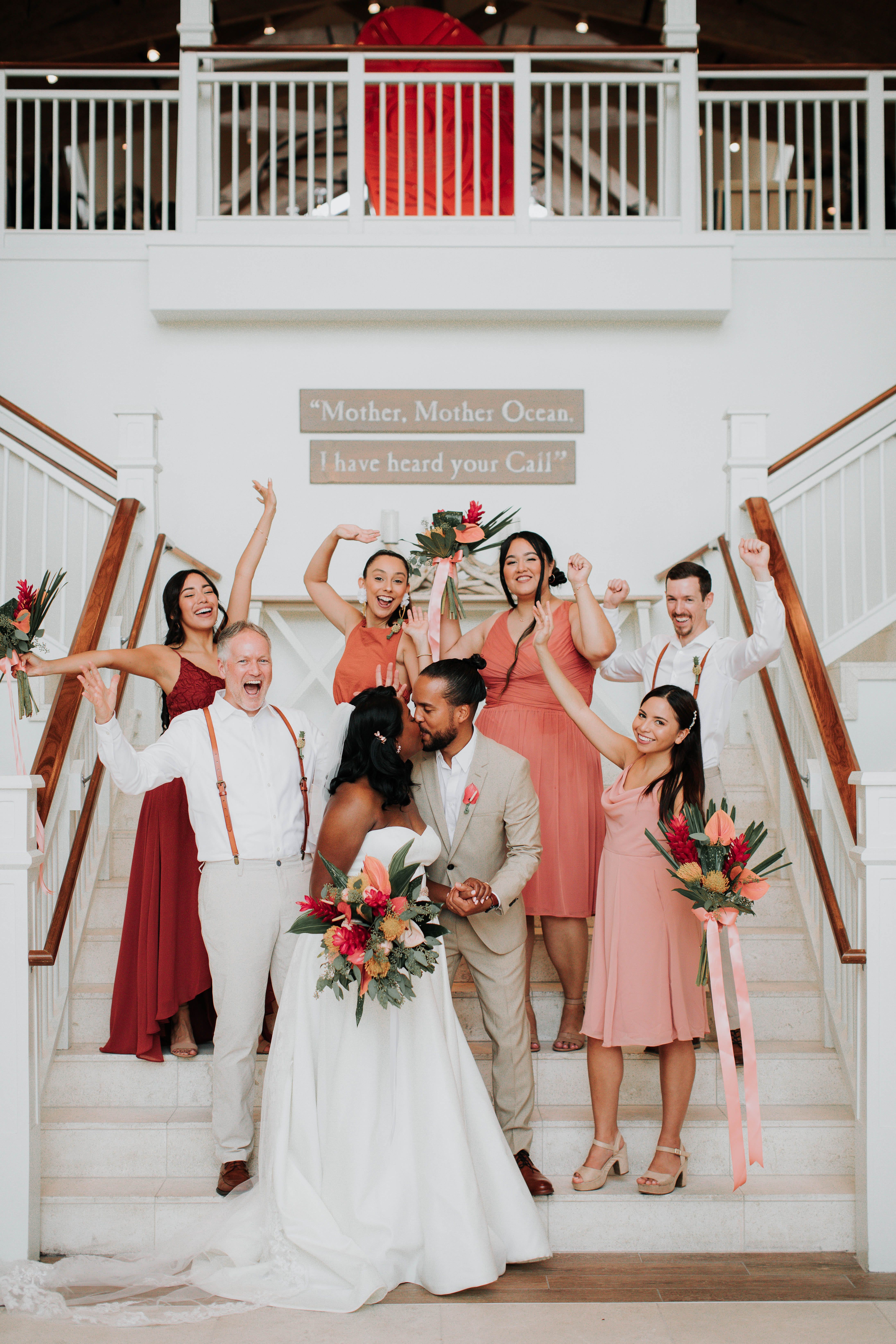 bride and groom kissing surrounded by bridal party