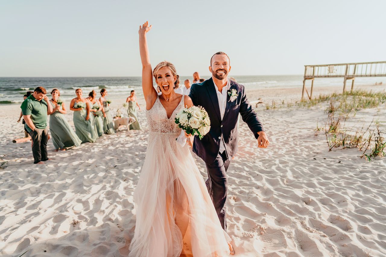 bride and groom celebrating after romantic beach wedding in Alabama