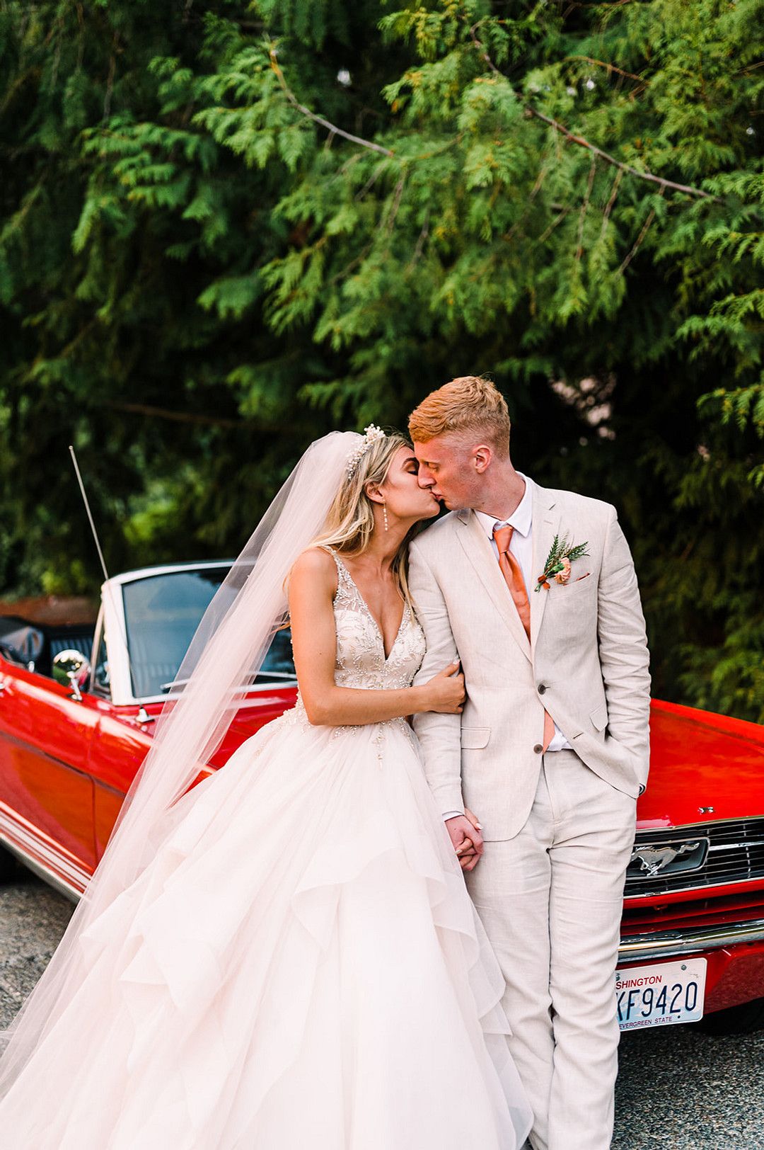 bride and groom in red convertible