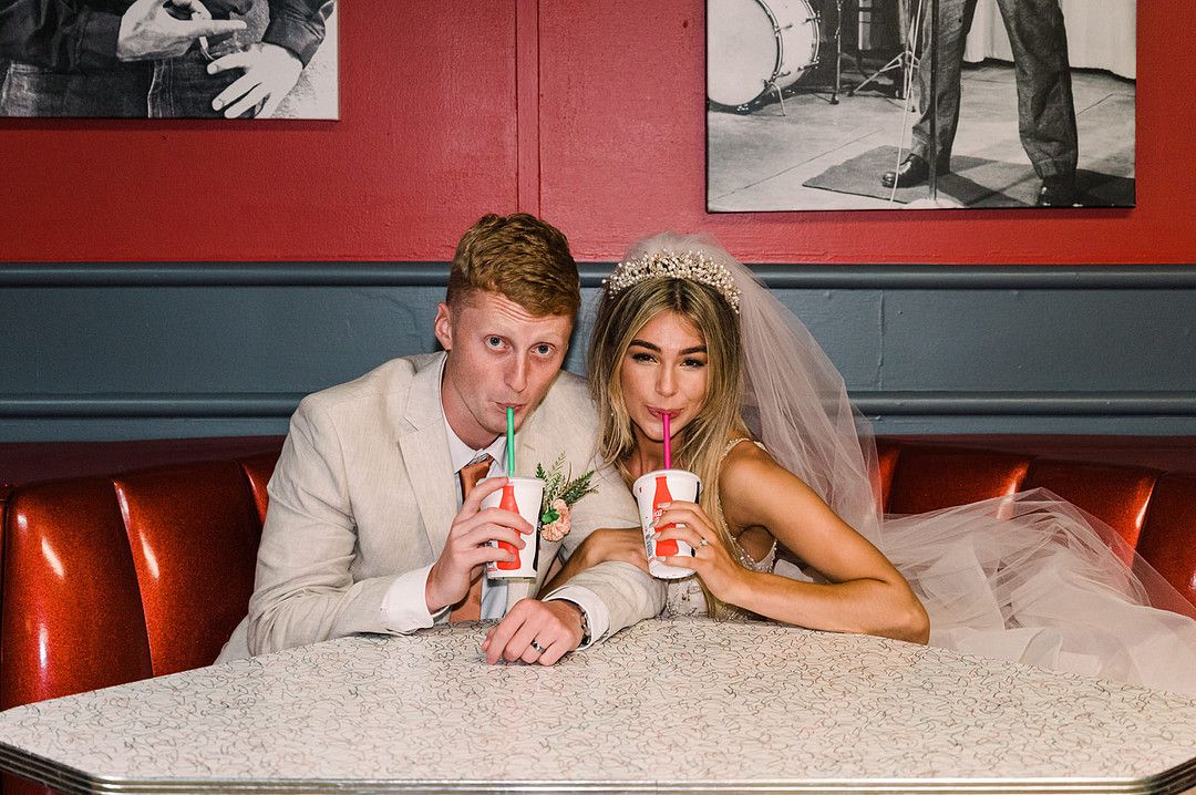 bride and groom drinking milkshakes