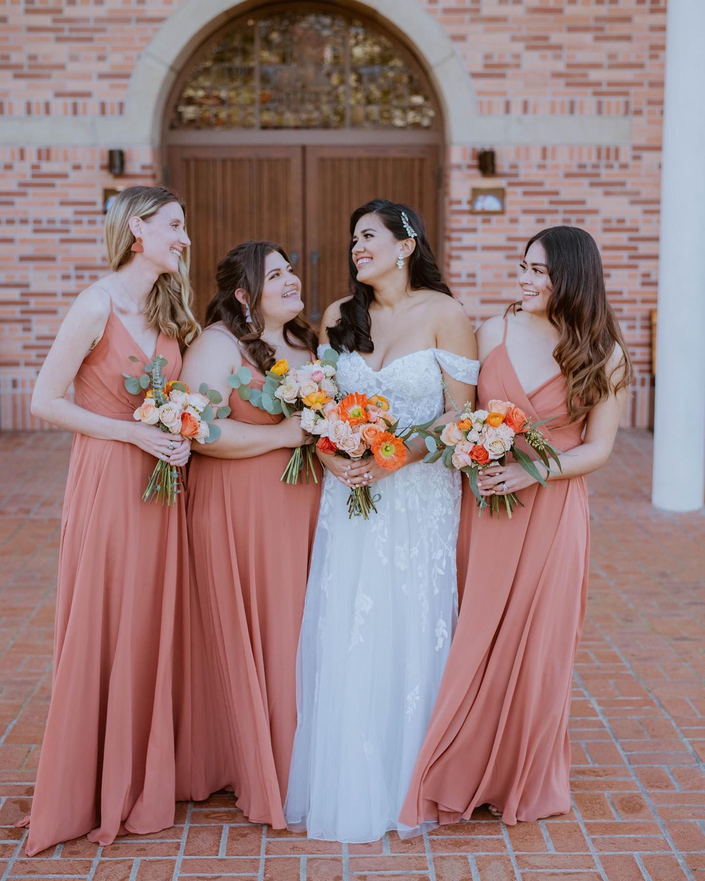 bride and bridesmaids wearing desert coral bridesmaid dresses