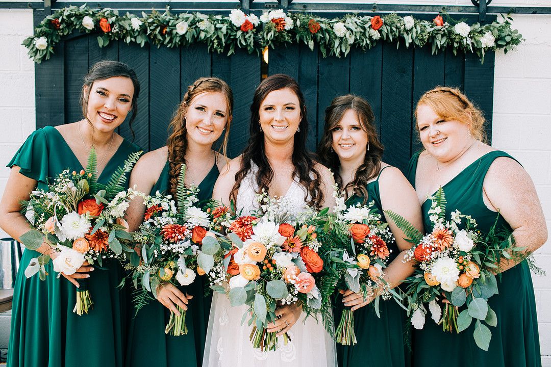 bridesmaids wearing green dresses with bride 